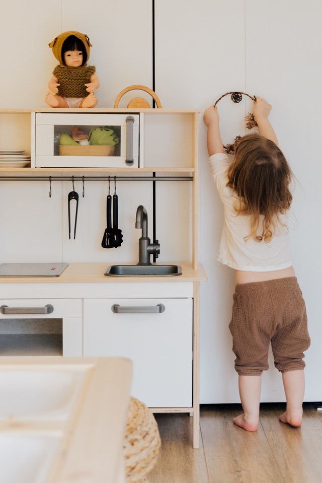 kid playing with kitchen set
